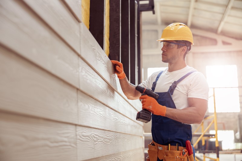 Handsome,Young,Man,Builder,Installing,Exterior,Wood,Siding